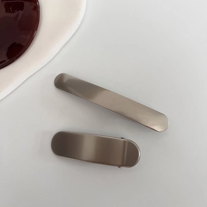 Fermagli per capelli minimalisti in metallo opaco grigio premium su fondo bianco