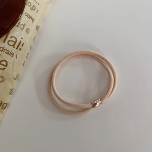 Dettaglio di elastico rosa per capelli con elegante fibbia in metallo oro rosa
