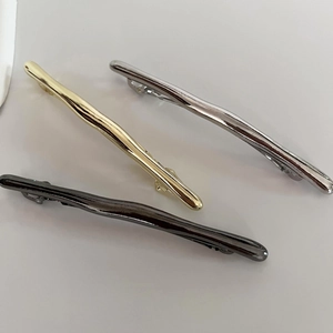 Minimalist metal hair clips in gold, silver, and black with unique liquid wave textures
