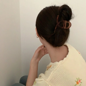 Elegant tortoiseshell hair claw clip with cutout D-shape design shown on model's hair