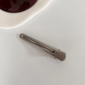 Dettaglio del fermaglio per capelli rettangolare grigio opaco con design cavo