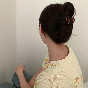 Detailed view of a tortoiseshell hair claw clip securing a classic French bun hairstyle
