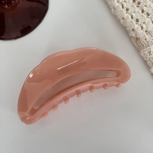 Détail d'une grande pince à cheveux rose pêche en acétate avec logo France Handmade doré