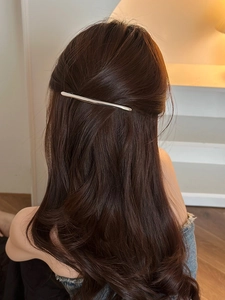 Minimalist silver spring hair clip styled on long wavy hair for a clean back view