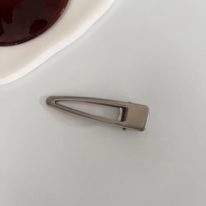 Dettaglio di fermaglio per capelli in metallo argento opaco con design a goccia d'acqua