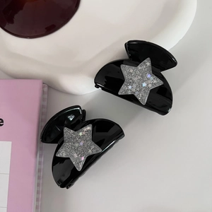 Close-up of black star hair claws with silver glitter stars for Y2K style hairstyling