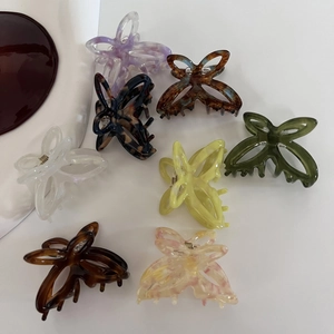 Flat lay of acetate butterfly hair claws in eight assorted colors and marble patterns
