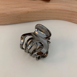 Detail view of small gunmetal hair claw clip with polished metallic finish and sturdy spring