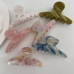 Detail showing marble texture and Barrette La France gold lettering on acetate hair claws