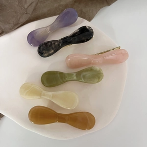 Close-up of marble textured acetate hair clips in six colors on a decorative tray