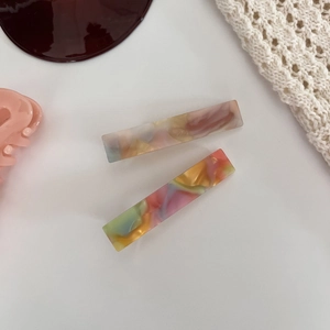 Detailed macro view of rectangle hair clips with colorful marbled acetate texture