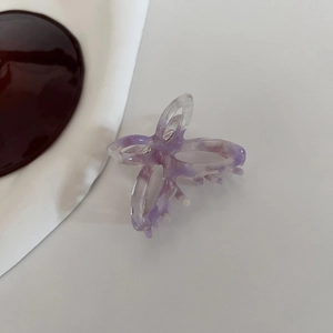 Macro detail of purple marble acetate butterfly hair claw with hollow bow design