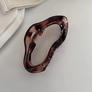 Gros plan détaillé sur une pince à cheveux ambre avec design ondulé élégant