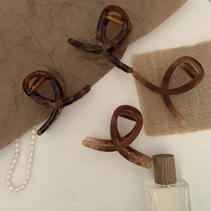 Detail of four chic tortoiseshell hair claws with elegant cross-twist resin design