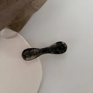 Detail of elegant resin hair clip with black and grey marble ink pattern texture