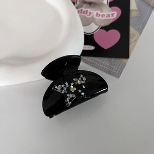 Close-up of black star hair claw clip with colorful sequins and glossy finish detail