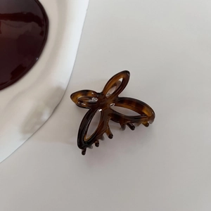 Detailed macro view of acetate hollow butterfly hair claw clip with tortoise shell pattern