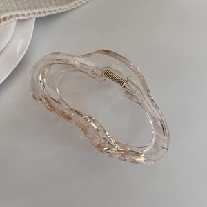 Détail d'une pince à cheveux champagne fluide avec ressort en métal doré