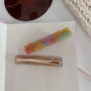 Detail of colorful acetate rectangular hair clips with gold metal duckbill fasteners