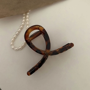 Detail of a tortoiseshell claw clip with amber resin texture and criss-cross design