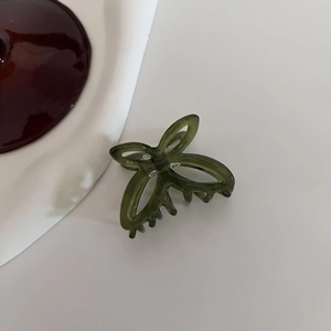 Close-up of a dark green acetate butterfly hair claw clip on a clean white background