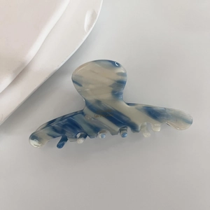 Detail of blue and white marble acetate hair claw clip with golden La France lettering