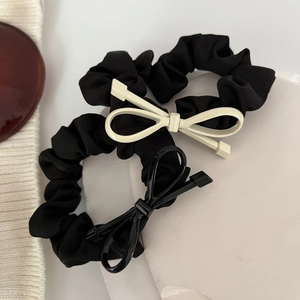 Dettaglio di eleganti elastici in raso nero con raffinati fiocchi su base di pietra