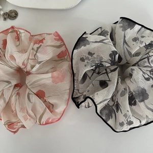 Détail de chouchous à fleurs imprimées à l'encre avec coutures contrastées sur fond blanc