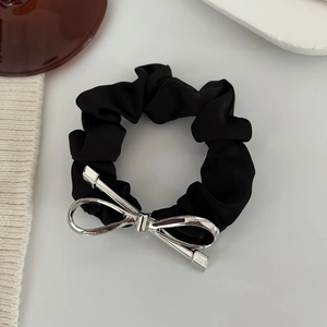 Dettaglio di un elastico in raso nero con un elegante fiocco in metallo argento