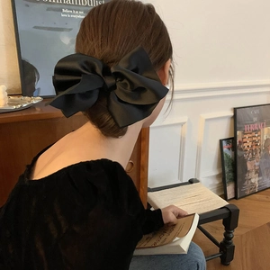 Elegant black satin bow hair clip accessory shown on model in a French vintage style