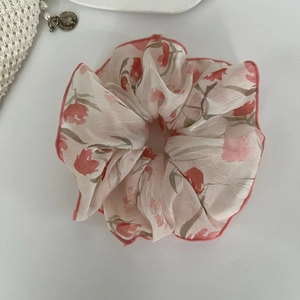 Détail du chouchou en organza avec imprimé tulipes rouges et bords roses cousus