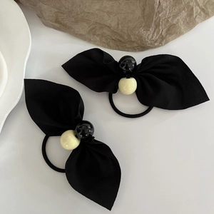 Elegante Schleife Haargummis mit hochelastischen schwarz-gelben Perlen auf weiß