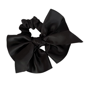 Elegant black satin bow hair scrunchie with a glossy silk texture and elastic hair tie