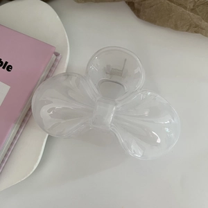 Macro detail of a transparent jelly resin bow hair claw clip with a silver metal spring