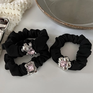 Detail of black scrunchies with silver bear and flower charms with pink crystals