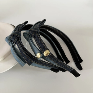 Close-up of denim fabric headbands with golden buttons engraved with motivational text