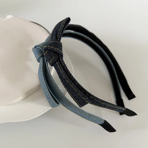 Detail of dark and light blue denim bow headbands on a modern ceramic tray display