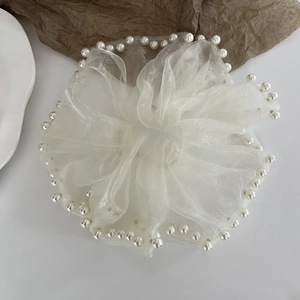 Detail of white oversized organza scrunchie with elegant faux pearl trim edge