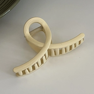 Close-up of twisted cream hair claw clip with deep teeth for thick hair security