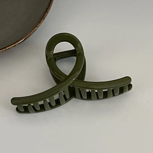 Detail view of dark green matte hair claw clip with large teeth for thick hair