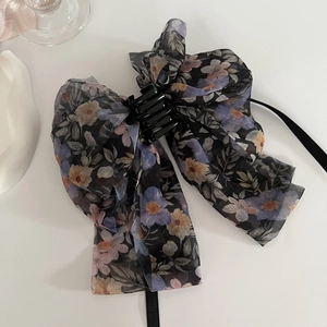 Detail von floraler Haarklammer mit Chiffon-Schleife und zartem Blumenmuster in Blau