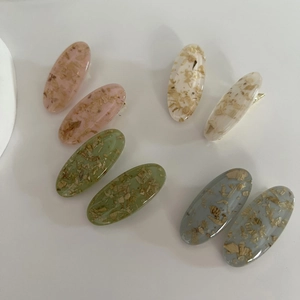 Set of oval resin hair clips in pastel colors with gold metal duckbill fasteners