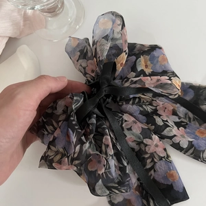 Detail der floralen Chiffon-Schleifen-Haarklammer mit langen schwarzen Bändern und Blumen