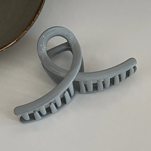 Detail shot of the sturdy grey-blue hair claw clip with interlocking teeth and twisted design