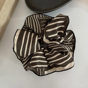 Macro shot of French style striped satin scrunchie with detailed stitching and soft pleats