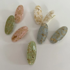 7-piece set of oval resin hair clips in pastel colors with natural wood chip inlays