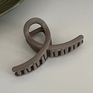 Detail of milk tea color shark hair claw clip with large teeth for thick hair