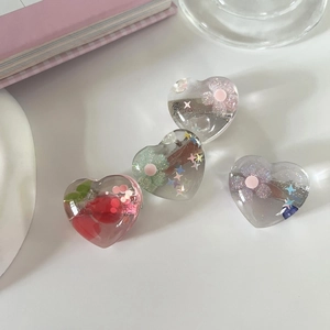 Nahaufnahme von vier Herz-Haarspangen aus Kunstharz mit Kirschmotiven und Glitzerdetails