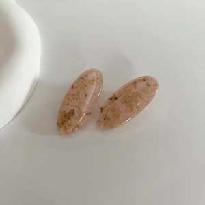 Pair of oval pink resin hair clips with gold foil flakes and smooth glossy finish