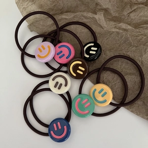 Lot de chouchous colorés à visage souriant avec élastiques sur fond blanc